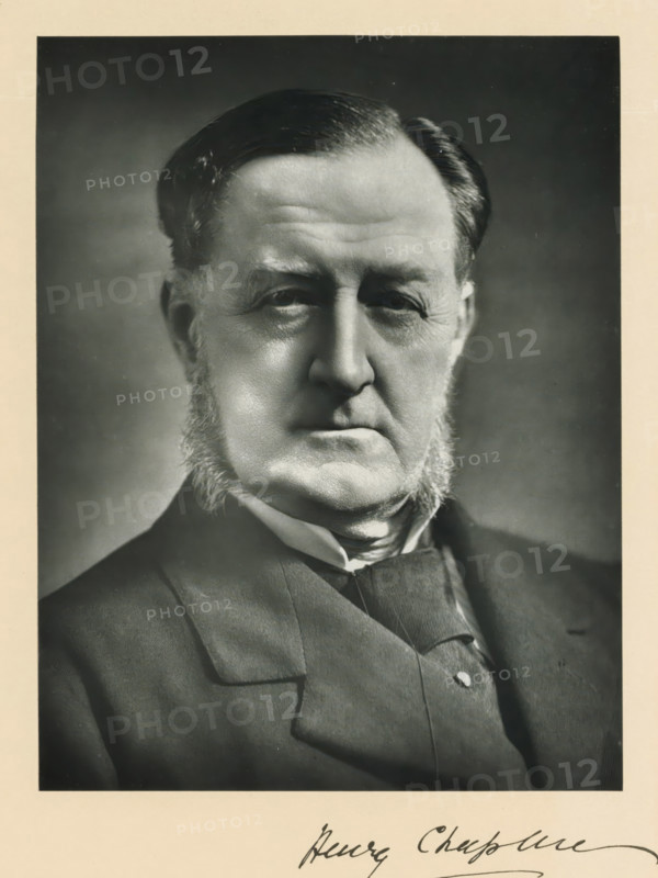 The right honorable Henry Chaplin, photograph, page, inscription: '55. Baker St. London, W.', annotation, photographer: Elliott & Fry, London, c. 1893 - c. 1903, paper, carbon print, height 222 mm x width 171 mm, Person, Henry Chaplin, historical persons (portraits and scenes from the life) ((full) bust portrait), A black and white close-up portrait of an older man showing his head and upper torso, with neatly combed dark hair, prominent sideburns, a serious facial expression, deep-set eyes, and visible facial wrinkles; he is wearing a dark suit jacket, a vest, and a high-collared shirt with a cravat, and the image has a light border around it.