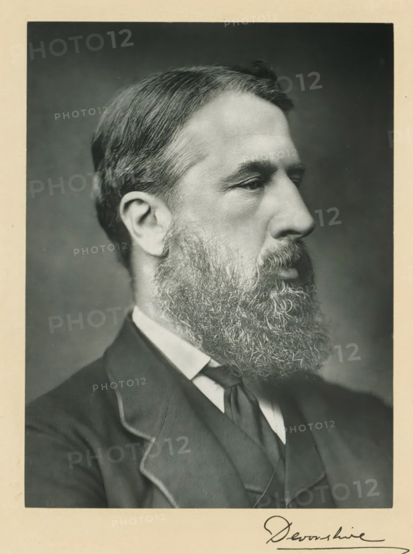 Our conservative and unionist statesmen division 1, book, photographer: various manufacturers, publisher: Newman, Graham & Co., London, c. 1900 - c. 1903, pasteboard, paper, printing, carbon print, height 367 mm x width 280 mm x thickness 23 mm, A grayscale close-up portrait of a man in profile showing his head, neck, and upper chest against a plain dark background, with neatly combed hair, a full bushy beard, and a mustache; he wears a collared shirt with a necktie and a dark suit jacket with visible lapels, and the image is framed by a light border.