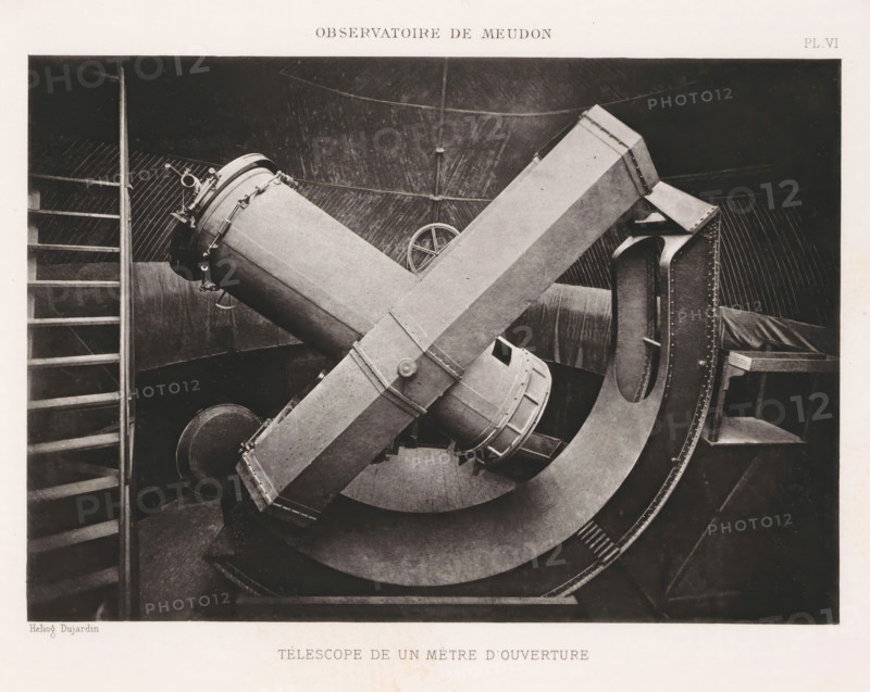 Telescope with a diameter of one meter of the Paris Observatory, Observatoire de Meudon - Coupole du telescope de 1m d'ouverture, page, photomechanical print, inscription: 'PL. VI', maker: Dujardin, c. 1891 - in or before 1896, Dujardin, paper, photoaquatint, height 149 mm x width 213 mm, telescope, Paris, Observatoire de Paris, A black and white photograph showing a large, metal telescope mounted on a curved support inside a domed interior. The telescope consists of a cylindrical body with a flanged end and an attached crosspiece that forms an X shape with the main tube. Riveted metal plates and bolts are visible along the curved mount and support structures. A handwheel is visible near the center of the image, and a ladder with horizontal rungs appears along the left edge. The background shows a ribbed dome interior with radial lines and struts, and a padded or covered bench or platform is visible on the right. The image is framed by a margin of lighter paper.