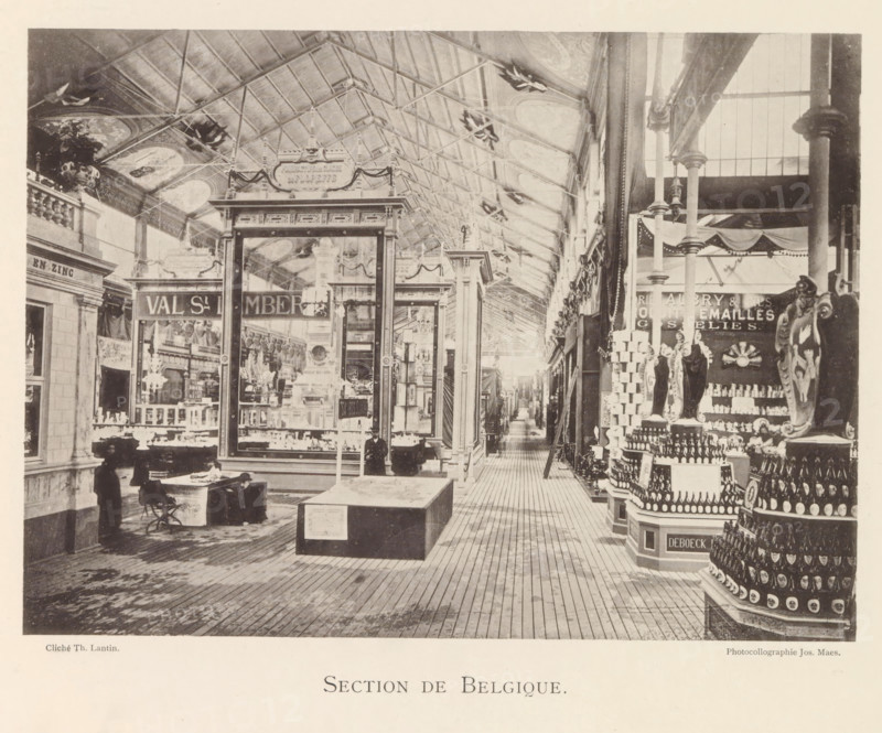 Section de Belgique, Expositie van Belgische beelden tijdens de wereldtentoonstelling te Antwerpen, page, photomechanical print, photographer: Th. Lantin, Antwerp, clichémaker: Joseph Maes, 1894, paper, collotype, light print, height 160 mm x width 220 mm, world fair, world exhibition, exhibition, show, A sepia-toned indoor scene of a long covered hall with a high pitched glass and metal roof and decorative ceiling panels, flanked by tall columns and ornate display booths, a central glass-fronted pavilion with framed panels and ornamental trim, wooden plank flooring leading down a narrow aisle lined with displays, shelving and stacked bottles, a tiered circular display of bottles in the foreground to the right, mannequins or sculpted figures among the displays, a few people in period clothing near the front left including a seated person at a small table and a standing figure, hanging lights and decorative garlands along the upper walls, and various framed mirrors, shelving units and m...