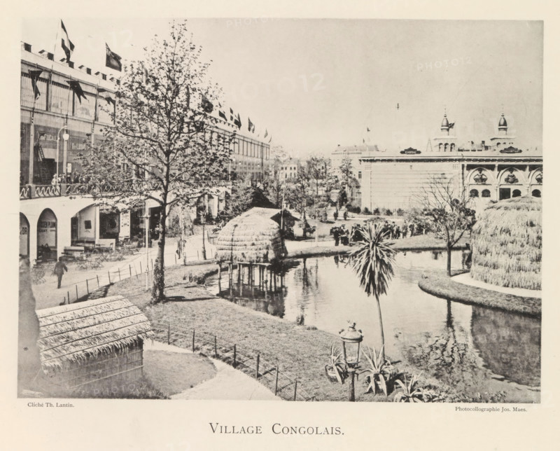 View of a recreated Congolese village during the world exhibition in Antwerp, Village Congolais, page, photomechanical print, photographer: Th. Lantin, Antwerp, cliché maker: Joseph Maes, 1894, paper, collotype, photoprint, height 160 mm x width 219 mm, village, colonial system, world fair, world exhibition, exhibition, show, A sepia-toned scene shows a landscaped area with a winding water canal bordered by grassy banks and a curved path, a thatched hut on stilts standing over the water, a smaller thatched structure nearer the foreground, and a palm-like plant rising beside the canal; on the left a multi-story building with arched ground-level openings and an upper gallery lined with flags and a tree in front, outdoor tables and chairs beneath the arches, and pedestrians on the walkway; in the distance a large classical building with decorative arches and towers is visible, and scattered trees, lampposts, and groups of people populate the grounds.