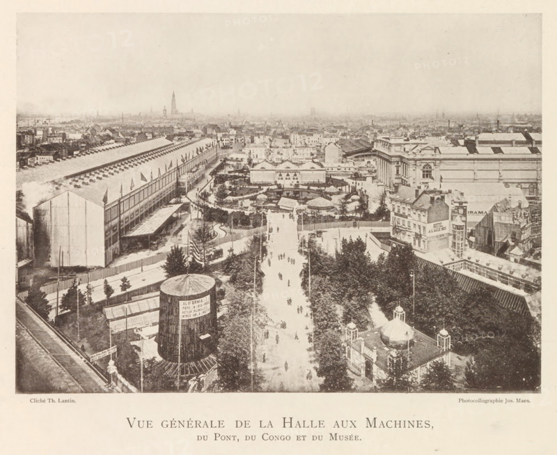 View of the world exhibition in Antwerp, Vue générale de la halle aux machines, du pont, du Congo et du musée, page, photomechanical print, photographer: Th. Lantin, Antwerp, printer (person): Joseph Maes, 1894, printer (person), paper, collotype, photoprint, height 157 mm x width 220 mm, facade (of house or building), world fair, world exhibition, World Exhibition 1894 (Antwerp), A wide elevated view of a cityscape showing a broad tree-lined avenue running toward the center with small figures walking along it, flanked by fenced gardens, paths, and clustered buildings; on the left a long industrial hall with a pitched roof and rows of small vents and flags along its side, and a large cylindrical structure in the foreground; on the right a block of ornate classical buildings with columned facades and adjacent smaller commercial structures; scattered tents, pavilions, and landscaped enclosures occupy the middle ground, while a dense spread of rooftops and church spires fills the distant ...