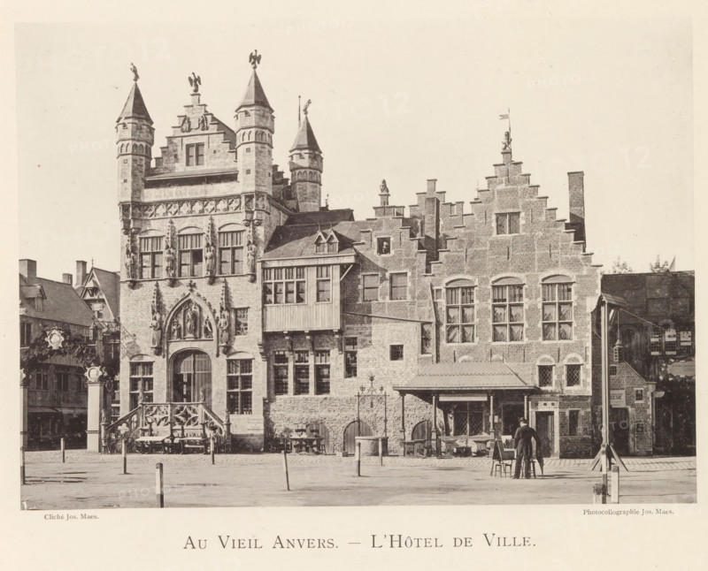 Exterior of the Schepenhuis and the Cloth Hall in Antwerp, Au vieil Anvers - L'Hôtel de Ville, page, photomechanical print, photographer: Th. Lantin, Antwerp, printer (person): Joseph Maes, c. 1890 - in or before 1894, Th. Lantin, Joseph Maes, photographer, printer (person), paper, collotype, photoprint, height 161 mm x width 224 mm, townhall, textile industry and clothing industry, facade (of house or building), A large stone building with ornate Gothic architectural details occupies the scene, featuring tall turrets topped with small statues, carved figures set into niches, arched doorways, and rows of multi-paned windows; adjoining stepped brick gables rise to decorative finials and a small flag, and a wooden projecting bay with diamond-paned windows connects sections of the façade; in front of the building a cobbled open area contains scattered wooden tables and chairs, a few short posts, and a man standing near a small table and chair arrangement, while decorative lamp posts and s...