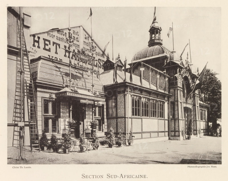 Section Sud-Africaine, Exterior of the South African pavilion at the World Exhibition in Antwerp, page, photomechanical print, photographer: Th. Lantin, Antwerp, printer (person): Joseph Maes, 1894, printer (person), paper, collotype, photogravure, height 158 mm x width 219 mm, façade (of house or building), world fair, world exhibition, A sepia-toned photograph shows an ornate exhibition building with a domed cupola and decorative roofline, multiple flags flying from tall poles, arched windows with mullions, and brick and timber facades; a canopied entrance with intricate trim and a small outdoor seating area with chairs and potted plants is visible in front, alongside a tall ladder structure on the left and a tree partially visible on the right.