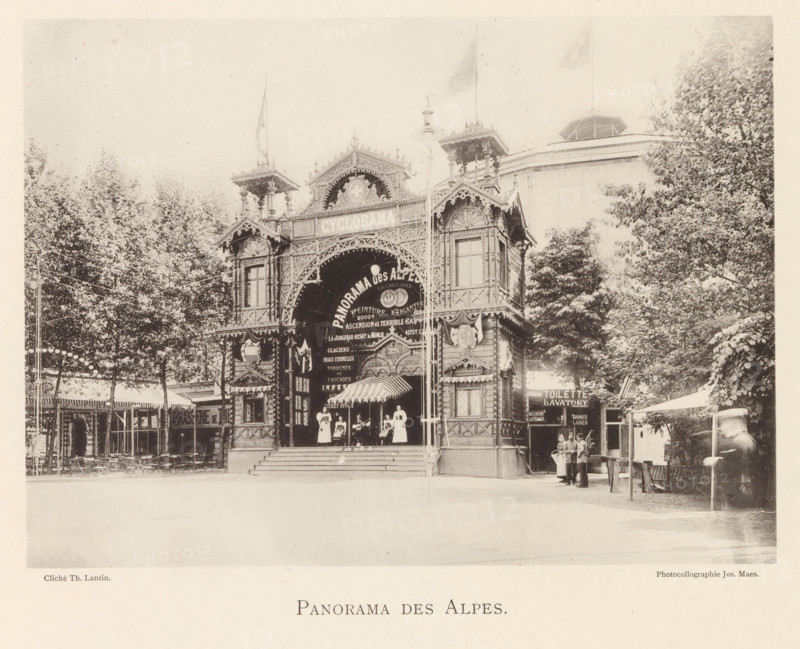 Exterior of the Panorama des Alpes at the world exhibition in Antwerp, Panorama des Alpes, page, photomechanical print, photographer: Th. Lantin, Antwerp, printer (person): Joseph Maes, c. 1890 - in or before 1894, printer (person), paper, collotype, photoprint, height 159 mm x width 220 mm, facade (of house or building), world fair, world exhibition, A sepia-toned photograph of a decorative wooden façade with ornate carvings, archways, and turrets surrounded by trees, with a striped awning over an entrance and several women standing on the front steps, a group of people gathered near a small signboard to the right, rows of outdoor seating and lamp strings visible to the left, and a blurred figure walking on the far right.