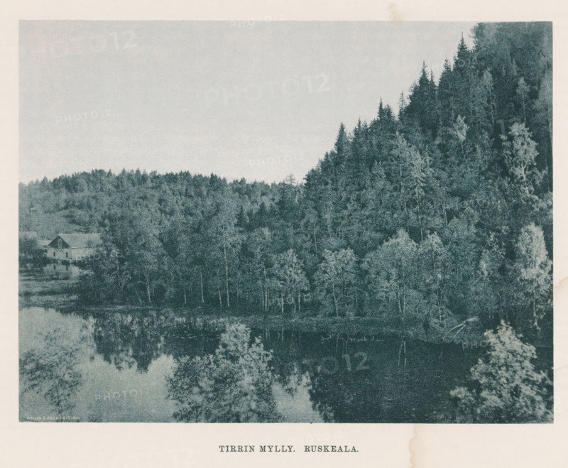 View of a river and the woods on the bank, Tirrin Mylly - Ruskeala, page, photomechanical print, photographer: Impi Backman, cliché maker: anonymous, printer (person): Weilin & Göös, c. 1888 - c. 1893, printer (person), paper, autotypie, height 167 mm x width 206 mm, trees, river, civic architecture, edifices, dwellings, Karelia, A landscape photograph showing a densely treed hillside on the right and a lower wooded area extending across the middle, with a calm body of water at the bottom reflecting the trees; a simple building with a pitched roof sits near the water at the left, partially obscured by trees, and the image has a wide pale sky above the treeline.