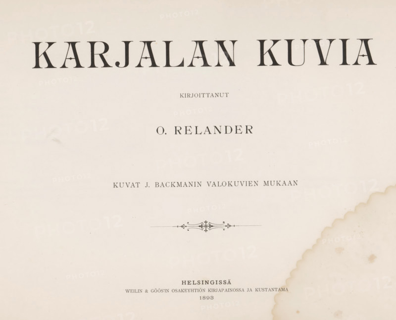 Karjalan kuvia, book, inscription: 'SEPT, 1995', photographer: Impi Backman, writer (clerical worker): Oskar Relander, printer (person): Weilin & Göös, Helsinki, c. 1893, writer (clerical worker), printer (person), pasteboard, paper, textile materials, printing, autotype, height 249 mm x width 342 mm x thickness 12 mm, A mostly blank off-white page with large dark serif shapes across the top, smaller dark serif lines and decorative flourishes centered lower on the page, and a scalloped brownish stain along the right edge with several small circular spots nearby.