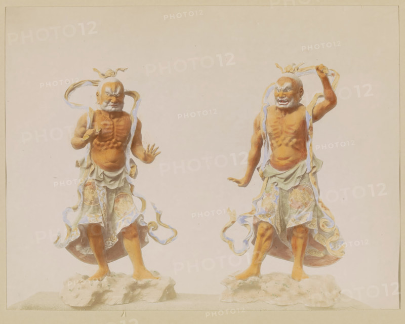 Two sculptures of temple guardians (Nio), photograph, page, Japan, c. 1887 - in or before 1897, photographer, colorer (graphic design artist), paper, albumen print, hand coloring, photographie peinte, height 186 mm x width 243 mm, Photo for page 265., sculpture, Hinduism, Buddhism, Jainism, guard duty, keeping sentry, Two sculpted figures stand on textured rock bases against a pale background, each depicted with muscular, detailed torsos and expressive facial features. Both figures wear flowing, patterned garments with swirling ribbons that wrap around their bodies and float outward. The figure on the left has one hand extended forward with fingers splayed and the other arm bent, a stern expression on its face, and a small topknot with ribbons. The figure on the right raises one arm above its head while the other arm is slightly lowered, showing a more open-mouthed expression and similar head adornment. The color palette includes warm skin tones, muted greens and blues in the clothing,...