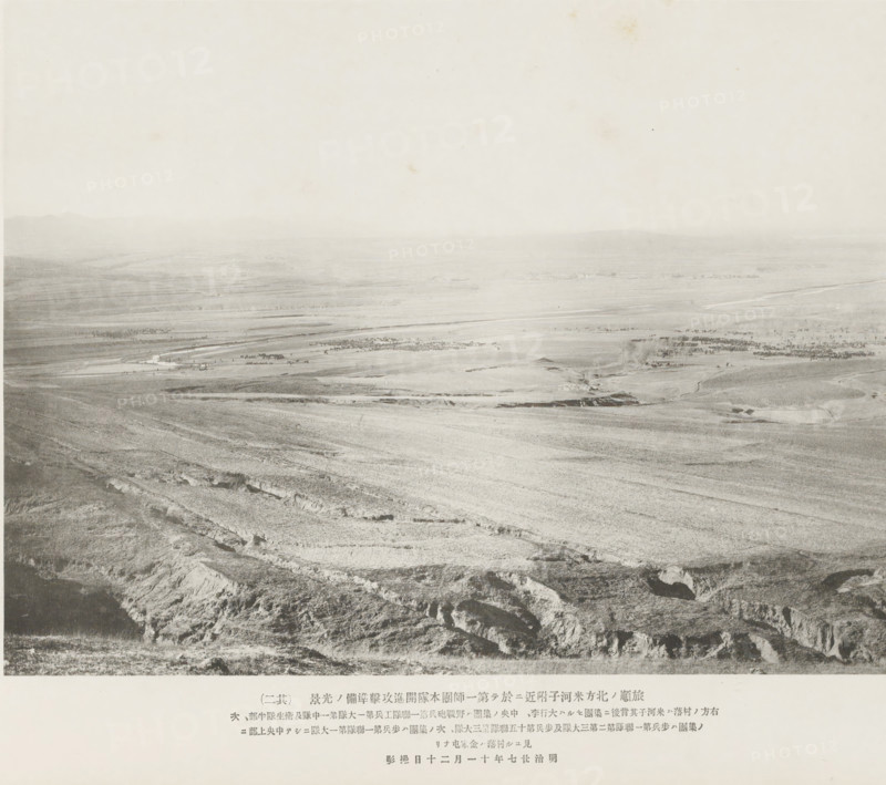 Preparations for advance and attack being made by the main body of the first division near Mehotse, N. of Port Arthur, page, photomechanical print, inscription: 'The fall of Port Arthur.', inscription: 'The village to the right is Mehotse, The village seen higher up in the center is Kinheatun.', photographer: Ordnance Survey, Manchuria, cliché maker: Kazumasa Ogawa, Japan, 1894-11-20, paper, collotype, photoprint, height 207 mm x width 273 mm, city-view in general, 'veduta', army 'en route', A wide, pale landscape photograph showing an expansive, flat plain stretching toward a distant horizon beneath a bright, nearly blank sky, with subtle variations in tone indicating fields and low ridges, a series of shallow terraces and eroded gullies in the foreground, faint linear patterns and scattered darker patches across the midground suggesting vegetation or grouped objects, a low line of hills visible far off, and a narrow band of printed material along the bottom edge.