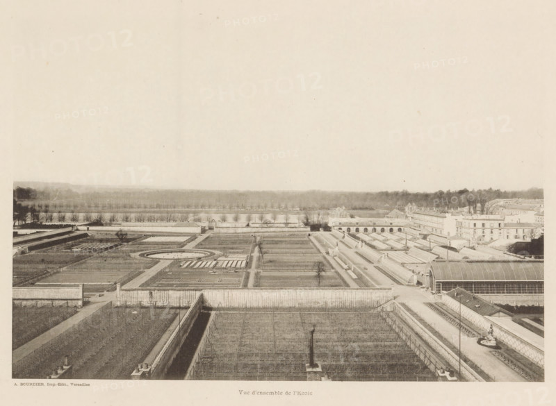 View of the École Nationale Supérieure d'Horticulture in Versailles, France, Vue d'ensemble de l'École, page, photomechanical print, Versailles, cliché maker: Alexandre Bourdier, printer (person): Alexandre Bourdier, publisher: Alexandre Bourdier, c. 1895 - in or before c. 1900, Alexandre Bourdier, photographer, cliché maker, printer (person), publisher, paper, collotype, photoprint, height 167 mm x width 228 mm, horticulture, vegetable culture, market gardening, education, botanic garden, 'hortus botanicus', École nationale supérieure d'horticulture, A wide aerial view of a formal garden complex with rectangular planted beds, pathways, and low walls leading toward a distant tree line, interspersed with long glass-roofed greenhouses and arched structures on the right, a circular planting feature near the center, rows of evenly spaced small trees beyond the garden, and a large open sky occupying the upper portion of the image.