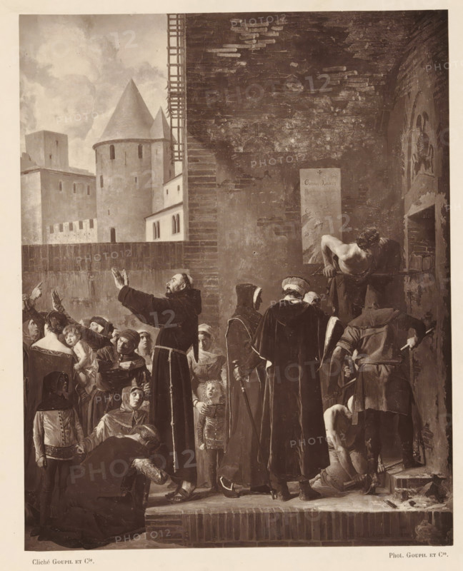 Photo reproduction of a self-portrait by Jean Paul Laurens, reproduction, page, photomechanical print, inscription: 'rue d'Assas, 84.', photographer: Charles Michelez, cliché maker: Goupil & Cie. (possibly), after painting by Jean Paul Laurens, c. 1876 - in or before 1879, Charles Michelez, Goupil & Cie., Jean Paul Laurens, photographer, cliché maker, after painting by, paper, Woodburytype, height 115 mm x width 85 mm, Person, portrait, self-portrait of painter, A crowded scene in front of a tall brick wall with an arched opening shows numerous figures in period clothing gathered closely together; a robed man with raised hands faces the crowd while others in long cloaks and hoods stand with canes, and a small child looks upward near their legs; on the right, a muscular shirtless man leans forward through the arched opening while another kneels on the ground near tools and a partially exposed stone threshold; many faces in the crowd show varied expressions and head coverings, and in the...