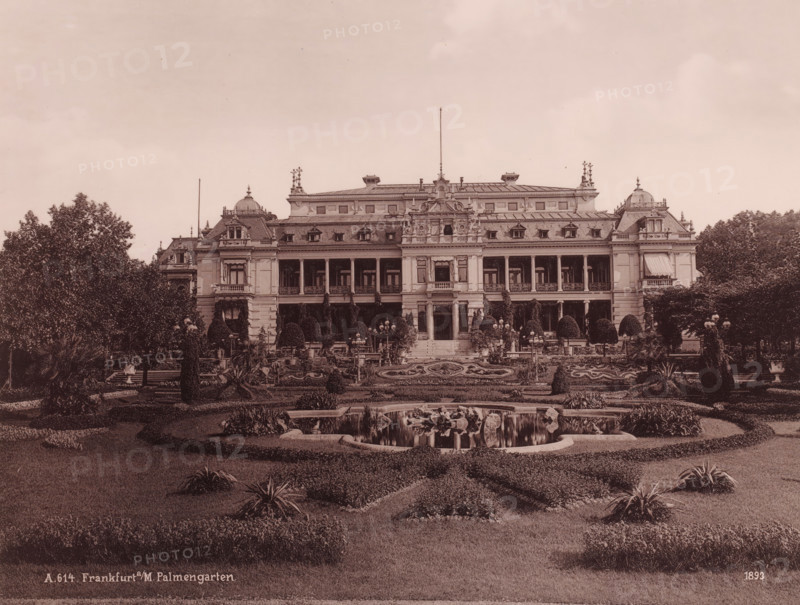 The 'Gesellschaftshaus' in the 'Palmengarten', Frankfurt am Main, Germany, photograph, The 'Gesellschaftshaus'in the 'Palmengarten' - this botanical garden was founded in 1868, and opened on March 16, 1871., date: '1893', inscription: 'A. 614. Frankfurt a, M. Palmengarten.', 1893, photographer, pasteboard, paper, albumen print, albumendruk, height 206 mm x width 270 mm, height 508 mm x width 330 mm, Hessen, A large ornate building with a symmetrical façade and multiple windows is centered behind a formal garden, featuring terraces, trimmed shrubs, and decorative lamp posts; the building has a mansard-style roof with dormer windows, ornamental sculptures and balustrades along the upper edges, and a central entrance with steps leading down to the garden; in front of the building a landscaped area includes patterned flowerbeds, clipped hedges, and a pond with rocks and water reflections, while mature trees and additional plantings frame the scene on both sides.