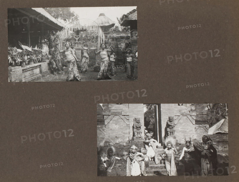 Two shots of a traditional dance, performed by children, album page, photograph, c. 1950 - c. 1960, photographer, paper, gelatin silver print, developed gelatin silver print, height 226 mm x width 289 mm, boy (child between toddler and youth), adolescent, young woman, maiden, girl (child between toddler and youth), ritual music and dancing, non-Christian religions, Dutch East Indies, The, A dark brown background with two black and white rectangular photographs mounted on it, the upper photograph showing a group of young people standing and performing in front of a brick wall and thatched roof structures, some wearing patterned skirts and wrapped tops and holding round trays, with decorative foliage and arching fronds overhead and arrangements on a low brick ledge to the left, and the lower photograph depicting several figures wearing ornate headpieces and traditional garments posed on stone steps between carved stone statues and brick architecture.
