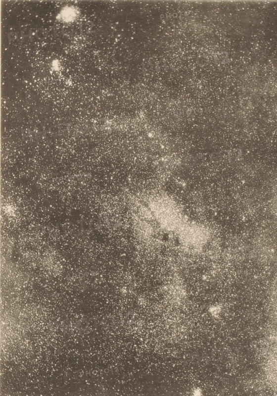 Region of the Milky Way in Sagittarius, Milky Way in the area of the constellation Sagittarius, page, photomechanical print, inscription: 'Showing a double black aperture.', number: 'Plate V.', photographer: Edward Emerson Barnard, cliché maker: anonymous, c. 1890 - in or before 1893, paper, collotype, photoprint, height 148 mm x width 107 mm, Milky Way, A grainy monochrome image filled with numerous small pale speckles and a few larger irregular light patches scattered across a darker background, with dense clusters of speckles forming lighter textured areas and some diffuse, cloudlike bright regions near the top and center.