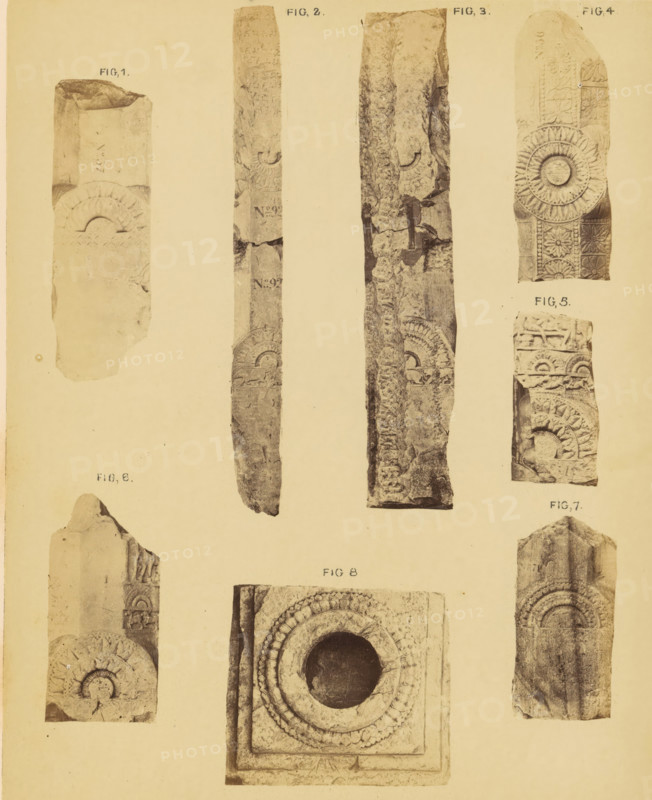Eight fragments of pillars, Amaravati, Andhra Pradesh, India, photograph, page, inscription: 'AMRAVATI. PLATE XC.', inscription: 'FRAGMENTS OF PILLARS., SCALE 1 INCH TO 1 FOOT.', photographer: William H. Griggs, c. 1863 - in or before 1868, South India, paper, albumen print, height 241 mm x width 194 mm, Photo two pages after page 210., column, pillar, architecture, Hinduism, Buddhism, Jainism, A vertical sheet showing multiple narrow photographs of carved stone fragments arranged in columns and rows, each fragment displaying circular rosette and arch motifs, textured weathered surfaces, and chipped edges; the fragments vary in shape with some long and slender and others short and blocky, featuring repeating carved petal patterns, concentric rings around a recessed circular opening, rectangular borders, and decorative panels with floral and geometric relief; the background is a pale uniform tone and the images are evenly spaced across the page.