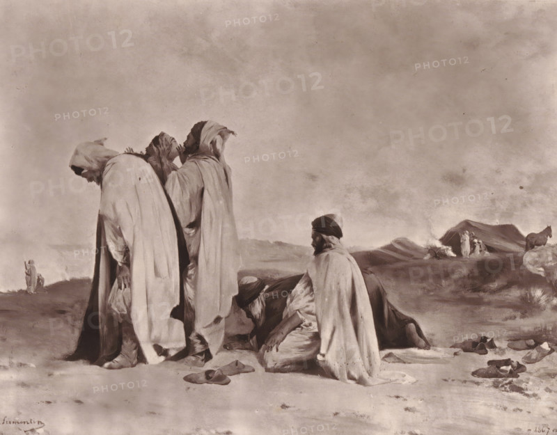 Arabes en prière, Reproduction of Arabes en prière by Eugène Fromentin-Dupeux, reproduction, page, photomechanical print, inscription: 'Eugène Fromentin, Galerie Contemporaine, Littéraire et Artistique, 126, boulevard Magenta, Paris.', cliché maker: Goupil & Cie., after painting by Eugène Fromentin-Dupeux, c. 1871 - in or before 1876, photographer, paper, Woodburytype, height 168 mm x width 217 mm, painting, drawing and the graphic arts, ritual objects and ritual means, non-Christian religions, Three robed figures stand in the foreground with their heads covered, one leaning forward and another touching his face, while two men kneel nearby with covered heads and loose cloaks; scattered sandals lie on the ground around them. In the middle distance a small group of people stands near a low mound of earth or dunes with smoke rising nearby, and a horse stands to the right. The sky above is broad and clouded with a mottled texture and the landscape is flat and sparse with gentle rises.