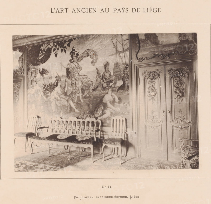 Room with a wall painting, L'Art Ancien au Pays de Liège, photomechanical print, This print is part of a cover with twenty prints, a title page and a list of images., number: 'No 11', Liège, printer (person): Ch. Claesen Éditeur, publisher: Ch. Claesen Éditeur, c. 1879 - in or before 1884, Ch. Claesen Éditeur, printer (person), publisher, paper, collotype, photogravure, height 164 mm x width 221 mm, wall-covering, other rooms, A sepia-toned photograph shows an ornate interior wall with a large decorative tapestry or mural depicting robed figures in a classical or mythological scene, with drapery, foliage, and a ship in the background; to the right are carved wooden double doors with intricate floral and ribbon motifs and raised paneling; in front of the wall a row of carved wooden chairs with upholstered seats and decorative cushions is arranged on a patterned rug, and an elaborately carved armchair with scrollwork is partially visible at the right edge.