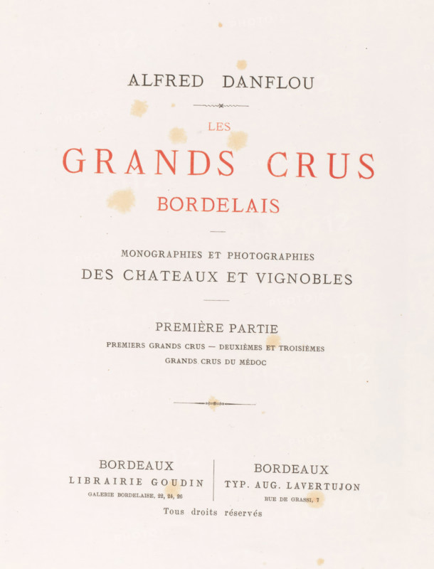 Les grands crûs bordelais : monographies et photographs des châteaux et vignobles, Alfred Danflou, book, date: 'SEPT, 1995', publisher: Librairie Goudin, Bordeaux, printer (person): Auguste Lavertujon, 1867, printer (person), textile materials, pasteboard, biological material, paper, leather, linen (material), printing, combined marbled paper, albumen print, height 357 mm x width 281 mm x thickness 46 mm, The image shows a cream-colored page with scattered pale brown stains and several horizontal ornamental lines; there are large red capital words centered near the top and smaller black lines of text and decorative elements arranged in a formal, symmetrical layout, with two columns of black text toward the lower half separated by a thin vertical divider and more pale brown spots across the page.