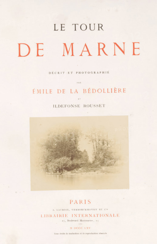 Le tour de Marne, book, photographer: Ildefonse Rousset, writer (clerical worker): Émile de La Bédollière, publisher: A. Lacroix, Verboeckhoven & Cie, Paris, publisher: Librairie Internationale, 1865, writer (clerical worker), textile materials, pasteboard, paper, linen (material), printing, albumen print, color on cut, lithography, height 309 mm x width 242 mm x thickness 32 mm, A mostly white page with a large faded rectangular photographic print near the center showing a waterside scene with trees along a shoreline and a small boat with a few indistinct figures; the page shows various lines of printed type above and below the photograph in dark and reddish ink, and the paper has a slightly aged, speckled appearance.