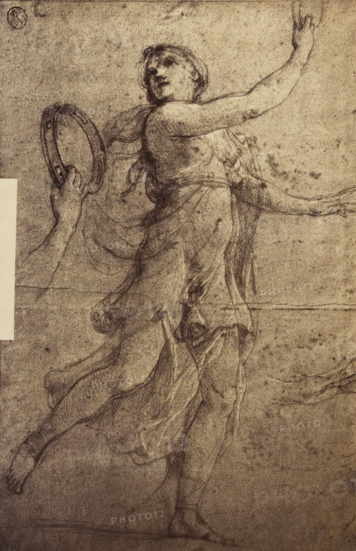 Photo reproduction of a drawing of a bacchante, photograph, reproduction, Part of a French artist's album., inscription: '...', after drawing by anonymous, c. 1880 - c. 1900, photographer, after drawing by, paper, albumen print, height 288 mm x width 192 mm, dancing, maenad(s), female bacchant(es), A sepia-toned sketch of a female figure in flowing drapery captured in mid-step, her torso turned with one arm raised and the other extended sideways, hair pulled back and head tilted upward with an expression suggested by shaded facial features, a hand holding a circular frame or tambourine near her side, visible limbs with defined musculature and feet poised as if walking, layered, translucent folds of cloth around her body and legs, a faint circular seal near the top corner, soft smudged shading across the background and paper texture with subtle creases and small spots.