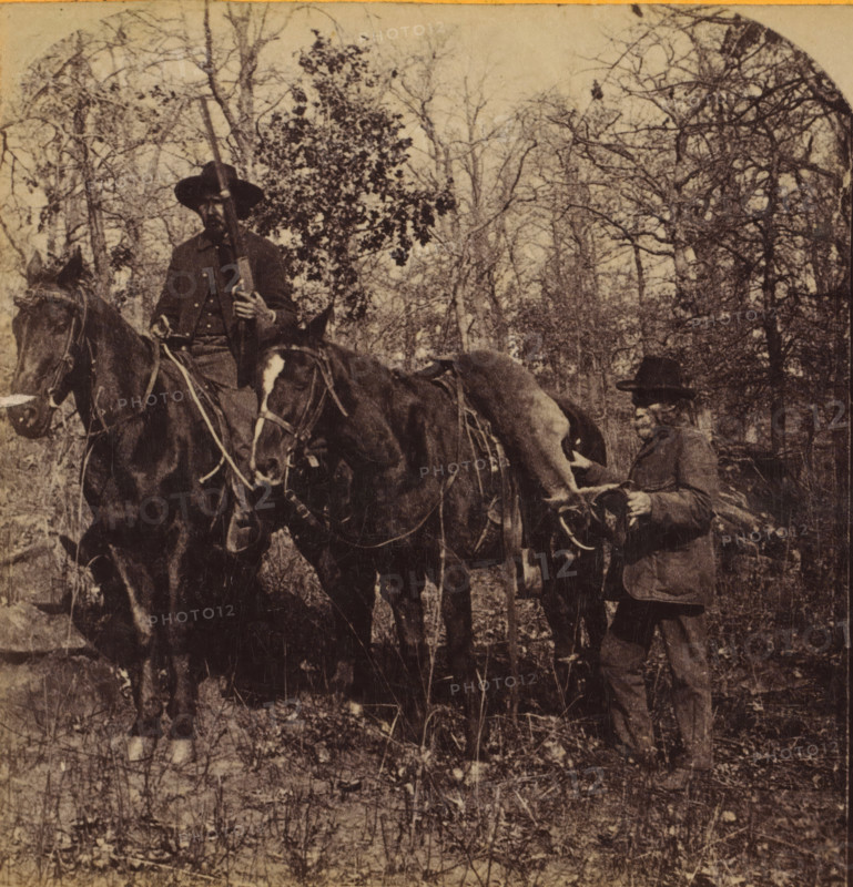 In the Boschveld, Two men on horseback with a shot hartebeest in South Africa, Faces and landscapes in Europe, Africa and Asia, Geographical Sculpture Gallery, collected by MJ Broekhuijsen, Headmaster of a school in Amsterdam, stereograph, annotation: 'One should not look for impenetrable forests here. The trees stand nowhere close together. Thorn bushes everywhere. The two Boers have shot a hartebeest and are bringing the prize 'home'. One can see from the horses that they have not yet been in war: they still gleam!', South Africa, publisher: Merkelbach & Co., Amsterdam, compiler (person in literature): Martien Johan Broekhuijsen, c. 1905, photographer, compiler (person in literature), pasteboard, paper, albumen print, height 86 mm x width 177 mm, Part of a group of 52 stereophotos used in primary education as a supplement to school charts. The entire series consisted of 274 items in 10 categories (A to K)., historical persons not known by name, hunt, hoofed animals (hunting with hors...