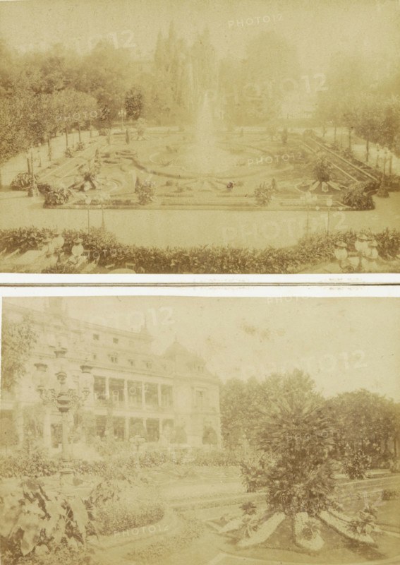 Fountain with flower beds in the Palm Garden of Frankfurt, probably seen from the Gesellschaftshaus, Frankfurt a. M. Im Palmengarten, photograph, cabinet photograph, Part of the Palm Garden in Frankfurt am Main., photographer: Johann Friedrich Stiehm, Palmengarten Frankfurt, in or after 1871 - c. 1880, Hessen, Frankfurt am Main, pasteboard, paper, albumen print, height 109 mm x width 168 mm, garden fountain, public gardens, park, botanic garden, 'hortus botanicus', A faded sepia-toned image shows a formal garden scene with a large central fountain spraying upward, surrounded by patterned flowerbeds and low hedges; lamp posts and decorative urns line the pathways, and a row of trees forms a backdrop behind the fountain; in the lower portion a grand building with multiple stories and balconies is partially visible, flanked by ornate street lamps and dense shrubbery, and the foreground contains various planted beds and a rounded cluster of spiky-leaved plants.