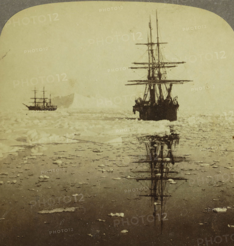 Whalers 'Diana' and 'Nova Zembla' sailing near Dexterity Harbour, Baffin Island, Whalers 'Diana' and 'Nova Zembla' cruising in the Arctics - Dexterity Harbor and Baffin Land, stereograph, inscription: 'K 5', inscription: 'Canada', number: '40, ', copyright notice: 'Copyright 1902 by Underwood & Underwood.', inscription: 'The Whalers, och Baffinslandet.', inscription: 'Works and Studios, Arlington, NJ Westwood, NJ Washington, DC', Dexterity Island, publisher: Underwood and Underwood, New York (city) (possibly), 1902, photographer, North America, pasteboard, paper, albumen print, height 88 mm x width 178 mm, whale fishery, whaling, ships (in general) - CC - more than one ship, drift ice, Two sailing ships are visible on a pale, textured sea surface, one larger and closer at right with tall masts and rigging and a dark hull casting a vertical reflection in the water, and a smaller ship farther left with multiple masts seen against a lighter background; the foreground shows scattered ice f...