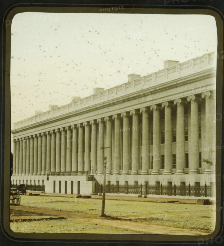 View of the Treasury Building in Washington DC, US Treasury, Washington DC, stereoscopic photograph, inscription: 'Entered according to Act of Congress, in the year 1856, by F. Langenheim, in the Clerk's Office of the District Court for the Eastern District of Pennsylvania.', inscription: 'F. Langenheim's Patent, Nov. 19, 1850.', photographer: Frederick Langenheim, 1856, North America, District of Columbia, inorganic material, glass, slide, hand coloring, height 85 mm x width 175 mm, treasurer, Treasury Building, A large neoclassical building fills the frame with a long colonnade of fluted columns topped by ornate capitals and an entablature with decorative molding and a balustrade along the roofline, a row of small roof structures visible above the balustrade; the façade shows a raised base with evenly spaced window openings and an iron fence running along the front, interrupted by a short flight of steps leading to a balcony with lamp fixtures; in front of the building a grassy area ...