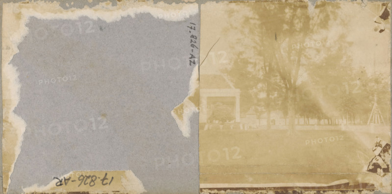 Park with building, stereograph, Originally this object was a stereophoto, but the left photo has been torn off., 1857 - 1870, photographer, pasteboard, paper, albumen print, height 85 mm x width 83 mm, park, A faded two-toned image divided vertically shows a left side of worn gray paper with torn beige edges and a small torn patch near the outer middle, and a right side of a sepia-toned photograph with a faint view of trees, a lawn, and a building with a columned porch structure partially visible through the haze, while a small section of patterned material or fabric appears in the lower right corner and several spots and stains are scattered across the surface.