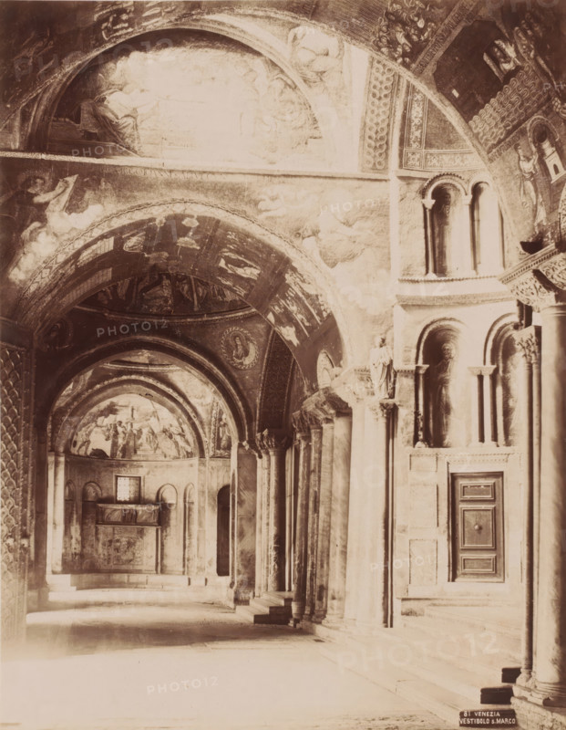 Vestibolo S. Marco, Vestibule of San Marco in Venice, Italy, Venezia, photograph, number: '81', Venice, 1851 - 1900, photographer, pasteboard, paper, albumen print, albumendruk, height 370 mm x width 321 mm, vestibule, hall, interior of church, Florence, Tuscany, San Marco, A high vaulted interior with a series of arches and columns, decorated ceilings with painted figures and ornamental patterns, niches set into the walls containing sculpted reliefs or statues, tall narrow windows with rounded tops, a carved door set into paneled stonework, and a distant apse area with frescoed scenes and architectural moldings.