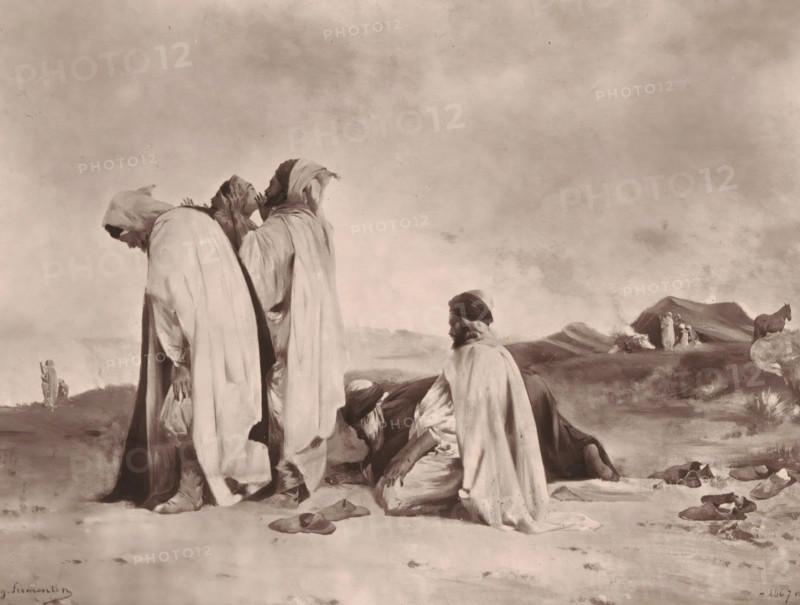 Arabes en prière, Reproduction of Arabes en prière by Eugène Fromentin-Dupeux, reproduction, page, photomechanical print, inscription: 'Galerie Contemporaine, Littéraire, Artistique, 126, boulevard de Magenta, Paris', cliché maker: Goupil & Cie., after design by Eugène Fromentin-Dupeux, c. 1872 - in or before 1877, photographer, paper, Woodburytype, height 168 mm x width 218 mm, painting, drawing and the graphic arts, ritual objects and ritual means, non-Christian religions, A group of robed figures occupies the foreground against a wide, clouded sky; three standing figures wear long draped garments with hoods and bowed heads, one of them holding a small bag, while two other figures kneel on the ground nearby with one facing slightly toward the viewer and the other bent forward. Scattered on the sandy ground are several pairs of simple footwear and a few small objects. In the middle ground a lone figure walks away toward distant low hills, and beyond them a small cluster of figures sta...