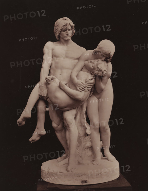 Les premières funérailles, Sculpture 'Les premières funérailles' by Louis-Ernest Barrias, page, photomechanical print, photographer: Adolphe Block, cliché maker: Goupil & Cie., after sculpture by Louis-Ernest Barrias, c. 1879 - in or before 1884, Louis-Ernest Barrias, after sculpture by, paper, Woodburytype, height 250 mm x width 195 mm, Adam and Eve discover the dead body of Abel and grieve over it, A pale marble sculpture of three nude figures is shown against a dark background, mounted on a round base. A standing male figure with wavy hair and a muscular torso faces slightly left, holding an adult limp figure across his arms; the limp figure has closed eyes and a relaxed head, with hair curling around the forehead. A second standing figure leans over the limp figure, pressing their face close to the limp figure's head while supporting the limp figure's torso with both hands. The sculpture shows detailed musculature, hair texture, and folded limbs, with visible feet on the base and d...