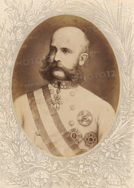 Photo reproduction of a painted portrait of Franz Joseph I, Emperor of Austria and King of Hungary, Franz Joseph I, Kaiser von Oesterreich, König von Ungarn, photograph, reproduction, page, after painting by anonymous, c. 1875 - in or before 1880, photographer, paper, albumen print, albumendruk, height 189 mm x width 143 mm, Photo on unnumbered page., Person, Franz Joseph I Karl (Emperor of Austria), historical persons, emperor, A sepia-toned portrait of a man shown from the chest up inside an oval frame, with a bald head and thick, curled sideburns and mustache, wearing a light-colored military uniform decorated with a sash across the chest and several ornate medals and badges, a high collar with decorative elements, and a neutral expression while looking slightly to the side, the oval portrait set against an illustrated floral and leafy border.