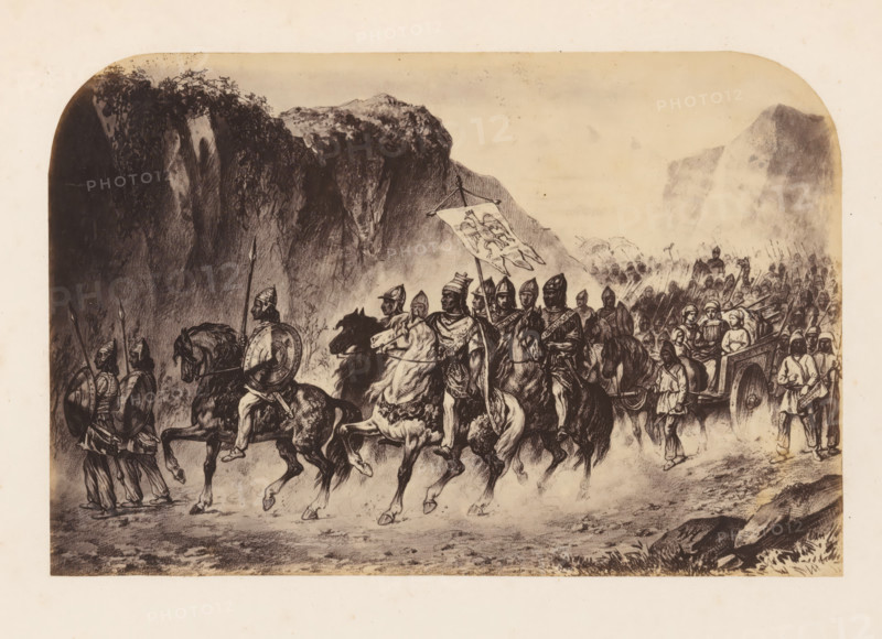 Photo reproduction of a print of Attila and the Huns, photograph, reproduction, page, photographer: Willem Adrianus van Hoek, after print by anonymous, c. 1856 - in or before 1861, after print by, paper, albumen print, height 138 mm x width 210 mm, Person, Attila the Hun, army 'en route', A sepia-toned illustration shows a procession of mounted warriors and foot soldiers moving along a rocky path beneath towering cliffs and vegetation. Several riders wear helmets and hold spears or shields, and one rider carries a large banner with a decorative design. Horses are depicted in motion, their legs raised as they walk or trot, and some riders wear cloaks or patterned garments. Behind the mounted group, a crowd of infantry advances carrying spears and standards, while a cart drawn by animals carries seated figures and is accompanied by attendants on foot. The background features steep, shadowed rock faces and distant rugged mountains under a pale sky.