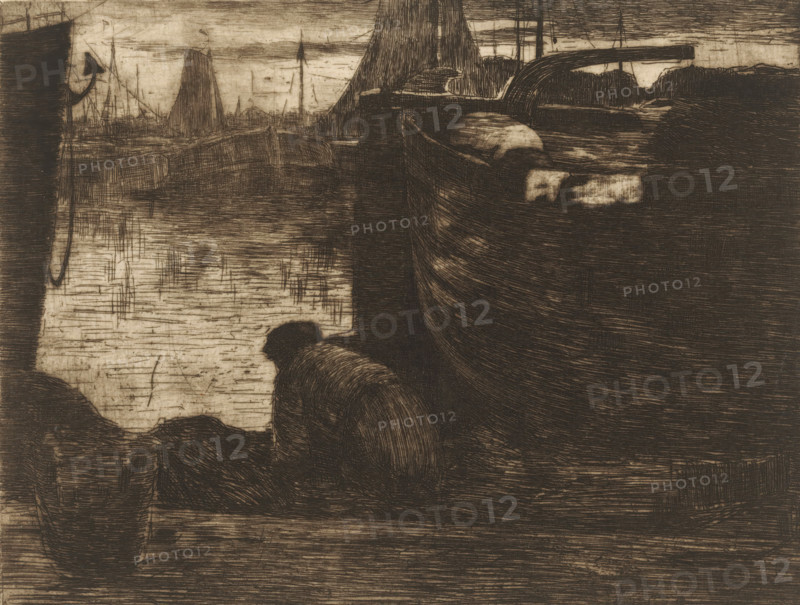 At the quay (original title), Man at the quay of a harbor, print, printmaker: Willem de Zwart (signed by artist), c. 1886, paper, etching, drypoint, intaglio printmaking technique, height 172 mm x width 218 mm, Print appeared in 1887 as part of the annual publication of the 'Portefeuille der Nederlandsche Etsclub'., harbor, pier, quay, wharf, A monochrome etching showing a waterfront scene with a large boat occupying the right side, its curved hull and deck rendered in dense crosshatching, and a smaller boat in the left foreground. A cloaked figure leans forward near the water at the center foreground, shown from behind. In the background there are masts and sails of other vessels along a distant shoreline and a horizontal structure or bridge arching above the water. The water surface is depicted with horizontal and vertical etched lines, and the overall image has a textured, scratched appearance.
