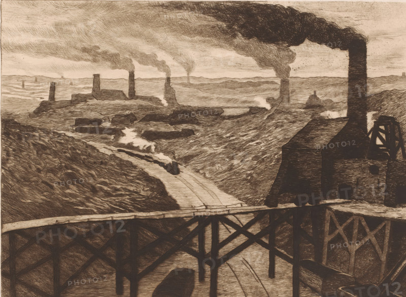 Industrial landscape with viaduct and a passing train, print, printmaker: Karl Meunier, after painting by Constantin Emile Meunier, 1892, paper, etching, intaglio printmaking technique, drypoint, plate tone and drypoint, height 206 mm x width 295 mm, The title of the painting from which the print was made is: 'Au pays noir'. This title refers to the name of the area 'Pays Noir', an industrial area around Charleroi., factory in landscape, railway, train, industries, Charleroi, A sepia-toned landscape rendered in dense etched lines shows a river valley with steep banks and a winding waterway flowing toward the foreground, crossed by a wooden trestle bridge with visible supports. Buildings with tall vertical chimneys stand on the ridges and along the valley, each chimney emitting billowing dark smoke that stretches across the sky. A small locomotive with a plume of steam is visible on the track running along the riverbank, and several rectangular roofed structures cluster near the chimney...