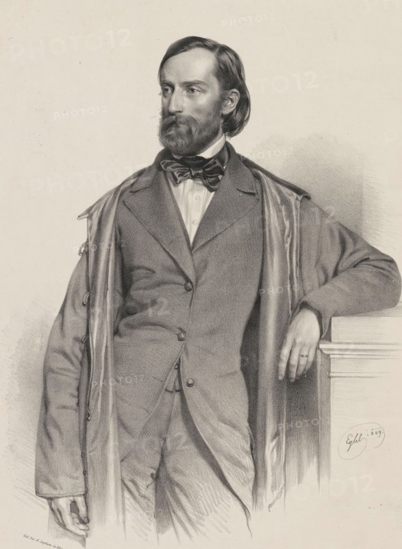 Portrait of Theodor Friedrich von Hornbostel, print, printmaker: Franz Eybl, printer (person): Alois Leykum, Vienna, 1849, printer (person), Lower Austria, paper, chine collé, lithography, height 580 mm x width 432 mm, Person, Theodor Friedrich von Hornbostel, historical persons, adult man, beard, A monochrome portrait of a man shown from head to mid-thigh, wearing a three-piece suit with a bow tie and an overcoat draped over his shoulders; he has medium-length hair combed back, a full beard and mustache, and a contemplative gaze directed to his left; his right arm rests on a ledge or column with his hand visible and a ring on one finger, while his left arm hangs by his side with the hand partially visible; the background is plain with subtle shading, and there is an artist's signature near the ledge.