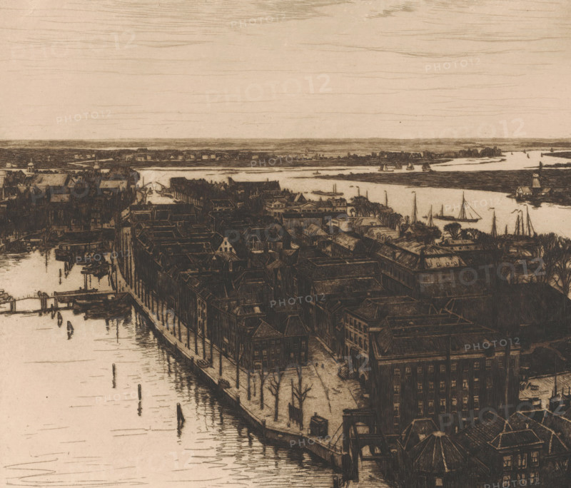 Harbour, Dordrecht (original title), Dordrecht I (original title), View of Dordrecht looking north from the tower of the Grote Kerk, print, annotation: '3rd state', printmaker: Willem Witsen (signed by artist), 1900, paper, etching, intaglio printmaking technique, height 323 mm x width 368 mm, city-view in general, 'veduta', river, A sepia-toned bird's-eye view of a riverside town showing rows of tightly packed buildings with pitched roofs lining a waterfront; narrow streets and leafless trees run between the buildings, and docks extend into the water where small boats and sailboats are moored or sailing; a winding river cuts across the scene with low-lying banks and scattered structures along its edge, and the distant horizon is marked by a thin strip of land under a pale sky streaked with fine horizontal lines.