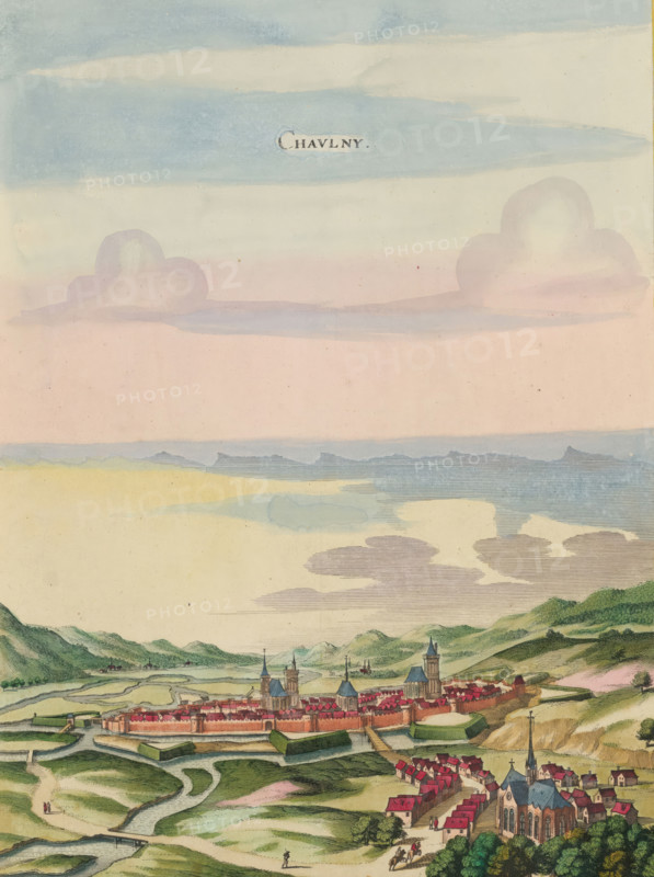 View of Chauny, Chaulny, print, album page, This print is part of an album., after drawing by Jan Peeters (I) (possibly), publisher: Caspar Merian, Frankfurt am Main, colorer (graphic design artist): Anna Beeck, The Hague, 1656, printmaker, colorer (graphic design artist), Hessen, paper, engraving, etching, hand coloring, etching and engraving, hand-colored, cut within the plate edge and pasted in a hand-colored frame, title cut out of the image and glued above it, surrounding sky and clouds hand-painted, height 381 mm x width 280 mm, height 532 mm x width 318 mm, A wide painted landscape shows a fortified town with red-roofed buildings and prominent church towers surrounded by walls and water-filled defensive earthworks, set against rolling green hills and small clusters of houses; winding pale paths and streams cross the foreground where a few small figures and riders are visible, and a larger church with a tall steeple stands near the lower right; above the town the sky displays lay...