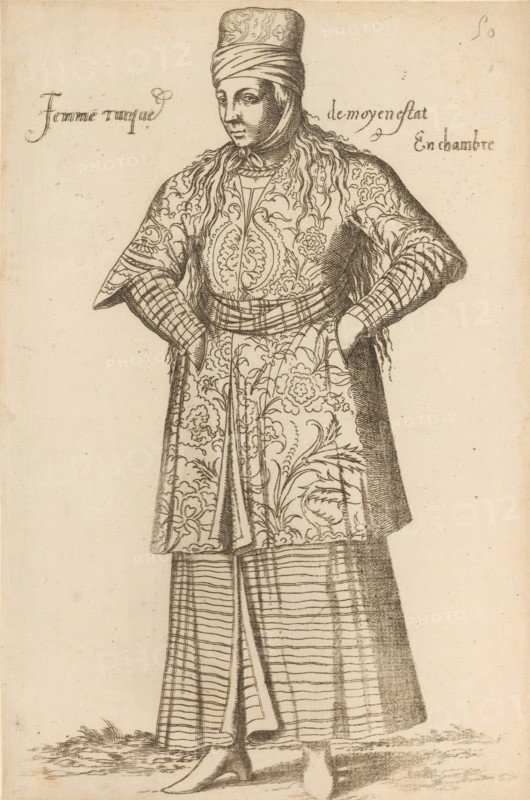 Turkish chambermaid, Femme turque de moyen estat En chambre, print, album page, book illustration, Print is part of an album., printmaker: Léon Davent, after drawing by Luca Penni (attributed to), after drawing by Nicolas de Nicolay (possibly), publisher: Guillaume Rouille (I), Lyon, 1555 - 1568, Attributed to, paper, etching, pasted on album page, height 263 mm x width 174 mm, A standing figure facing slightly to the side wearing a tall wrapped headpiece and a scarf tied under the chin, with long hair or hairlike strands falling over the shoulders; the figure wears a patterned long overgarment with floral and ornate swirling designs, a belted waist, and sleeves that appear layered with patterned cuffs, hands resting on the hips; below that a striped skirt with vertical and horizontal lines is visible over shoes with pointed toes, and the ground shows some grasslike texture.