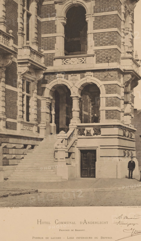 Town Hall of Anderlecht, Hotel Communal d'Anderlecht. Province de Brabant. Perron de Gauche - Loge inférieure du Beffroi, photomechanical print, maker: Joseph Maes, Antwerp, architect: Jules Jacques Ysendyck, 1879 - 1908, Joseph Maes, Jules Jacques Ysendyck, architect, paper, collotype, photoprint, height 524 mm x width 382 mm, town hall, Anderlecht, A sepia-toned photograph of a grand brick and stone building façade showing ornate architectural details, including a wide stone staircase leading to an upper terrace with balustrades, carved stone columns and arches forming a covered entrance, patterned brickwork alternating with horizontal stone bands, decorative stone reliefs and moldings around windows and archways, a pair of tall doors set into a recessed stone doorway at street level, a man in a dark suit and hat standing on the pavement near the corner of the building, another figure visible under the arches on the terrace, and a cobblestone street in front of the structure.