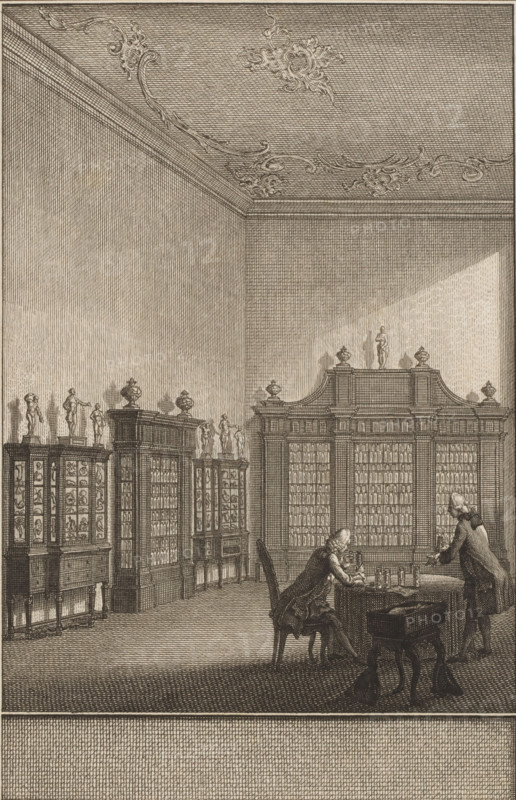 Cabinet of Bernhard Siegfried Albinus, print, In the cabinet of Bernhard Siegfried Albinus in Leiden, two men at a table study the contents of glass jars. Against the walls stand display cases with anatomical preparations., printmaker: Noach van der Meer (II), Leiden, Amsterdam, 1751 - 1822, paper, etching, engraving, etching and engraving, height 164 mm x width 108 mm, Person, Bernard Siegfried Albinus, study, 'studiolo', library, cabinet of curiosities, 'Kunst- und Wunderkammer', An interior room rendered in fine etching lines showing tall walls and an ornate ceiling with decorative scrollwork, large cabinets and bookcases lining the walls topped by small statues and urns, a central larger cabinet with columns of small compartments, two men in period clothing at a table in the foreground—one seated and leaning forward writing or examining objects, the other standing and leaning toward the table—various small bottles or instruments on the table, a chair and a small stool nearby, and l...