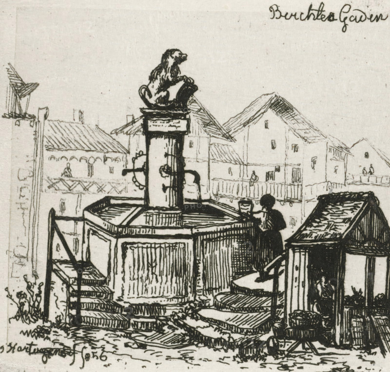 View of Berchtesgaden, print, printmaker: Joseph Hartogensis, The Hague, 1856, paper, chine collé, etching, etching on chine collé, proof print, height 63 mm x width 69 mm, ornamental fountain, Bavaria, Berchtesgaden, A black ink drawing shows a square fountain structure with a central column topped by a small seated dog sculpture, spouts and a basin around the column, and a person seated on the fountain edge holding a cup. Surrounding the fountain are wooden railings, steps leading up to the platform, and small buildings with gabled roofs in the background. Various linear hatching and crosshatching create texture on roofs, walls, and ground, and small potted plants and architectural details appear near the lower right and left edges.