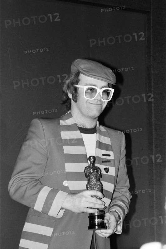 The 22nd Ivor Novello Awards, presented by BASCA and sponsored by PRS. Held at the Grosvenor House Hotel, London. Elton John pictured with his statuette for the Best Pop Song "Don¿ Go Breaking My Heart" . 12th May 1977.