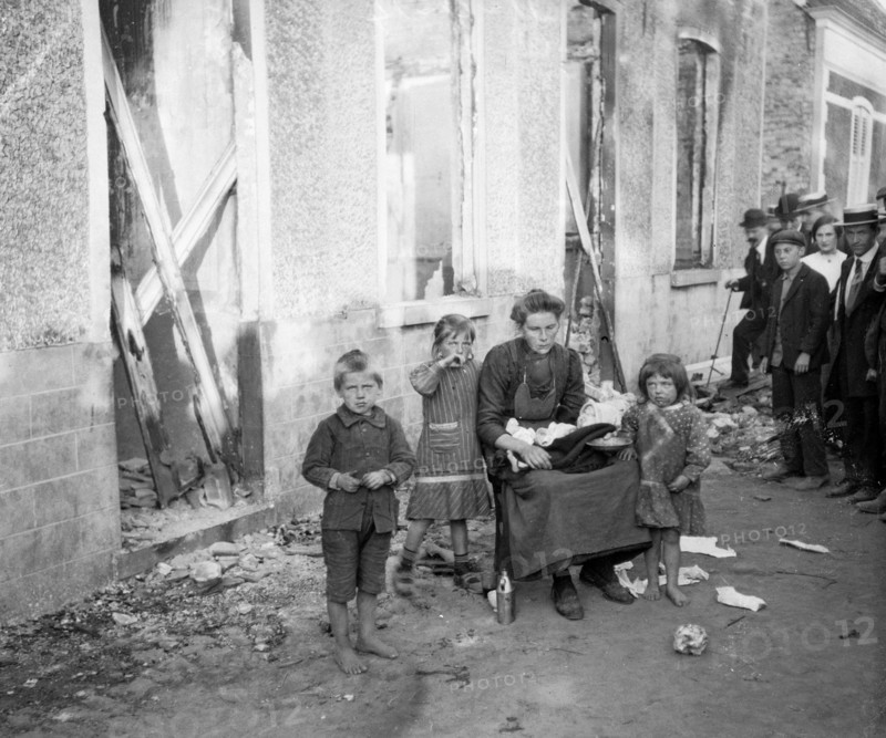 A poor Belgian woman outside her burnt out home in Melle with her four children