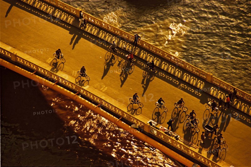 Bicycle riders on Fujianlu bridge across Suzhou river,Shanghai,China