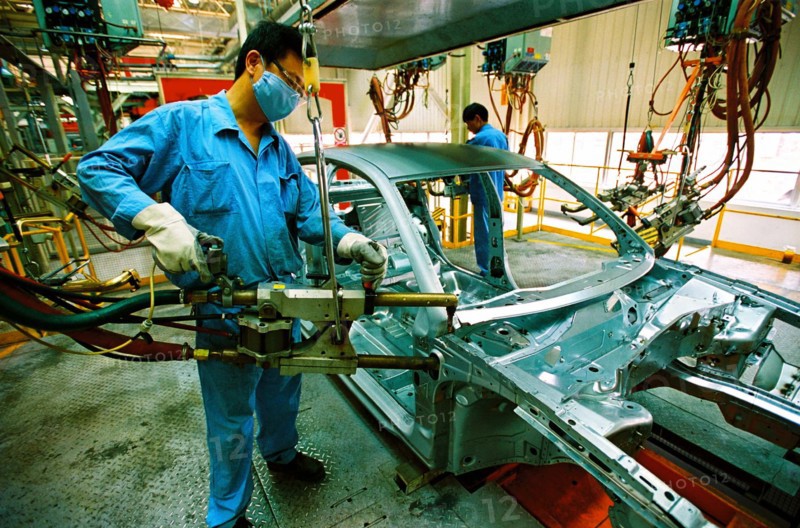 A worker welds in the workshop of Shanghai Volkswagen Automotive Company,Shanghai,China