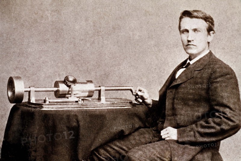 Thomas Edison posant à côté de l'une de ses inventions : le phonographe