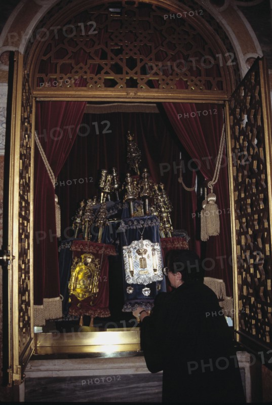 A woman rabbi in the West London synagogue removes the torahs from the Ark.