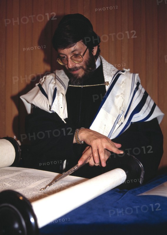 A rabbi reads from the torah in the synagogue